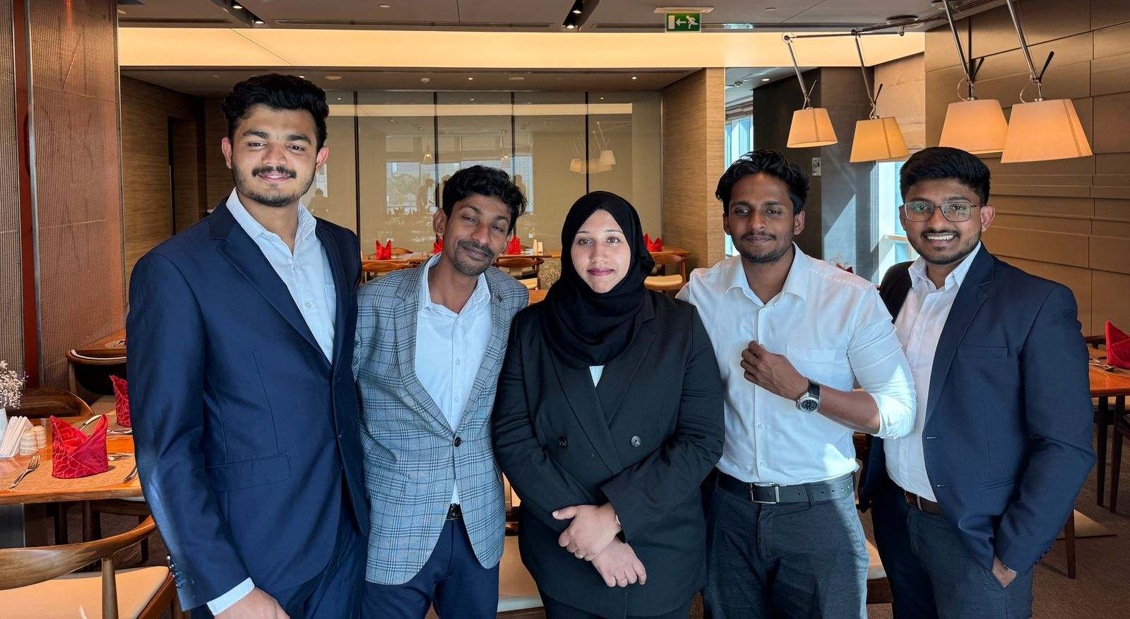 Five Missan UAE team members in business wear standing together in a hotel restaurant