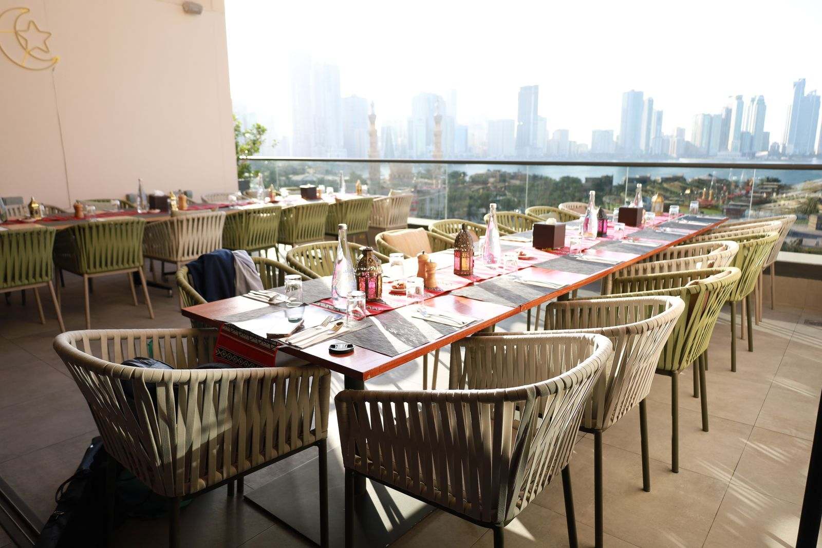 A long rooftop table set for iftar, with the city skyline behind