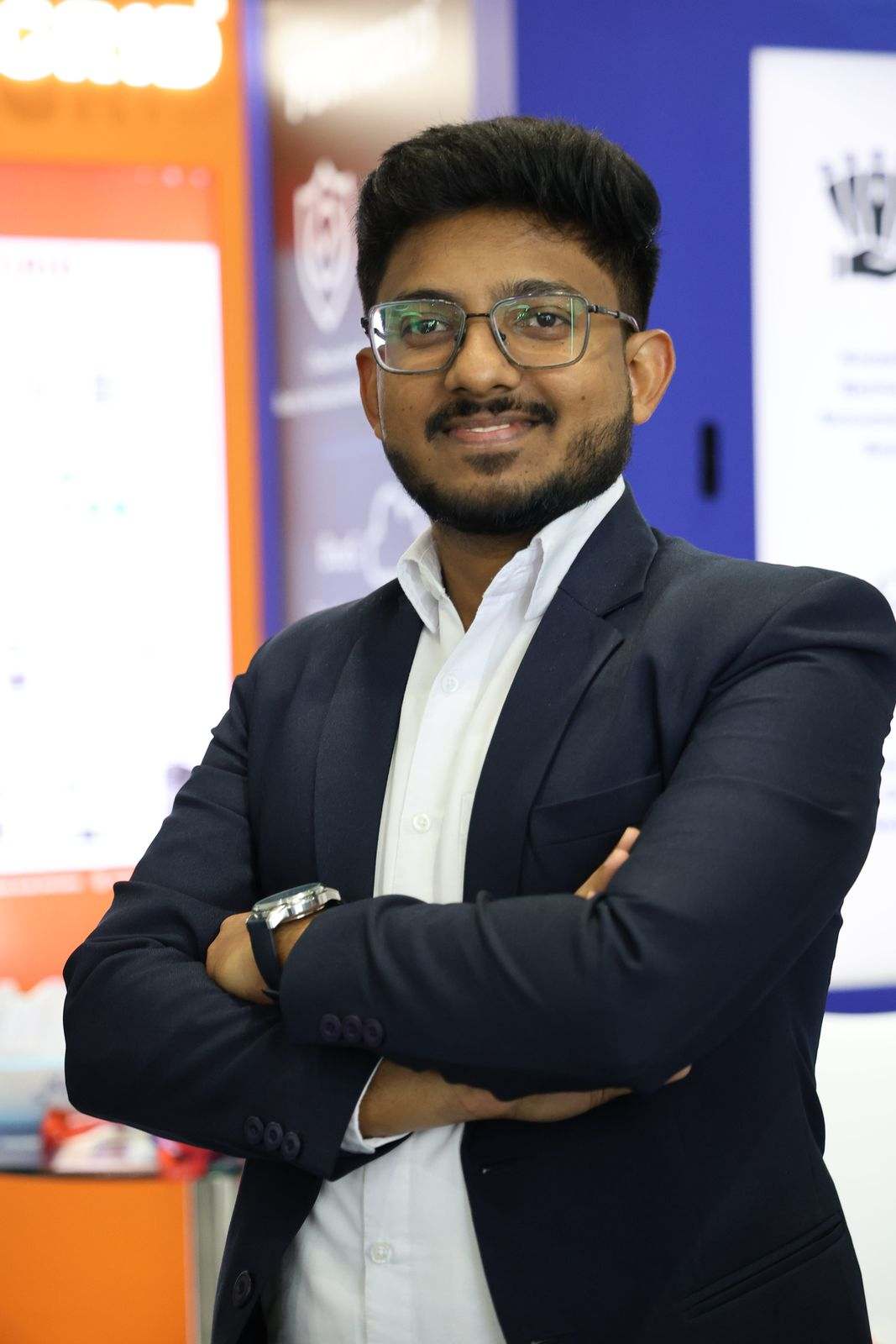 A smiling Missan team member in a dark suit with arms crossed on the Missan stand